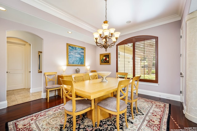 dining room with wood-type flooring, crown molding, and a chandelier