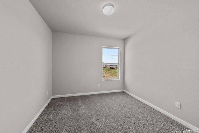 carpeted empty room featuring a textured ceiling