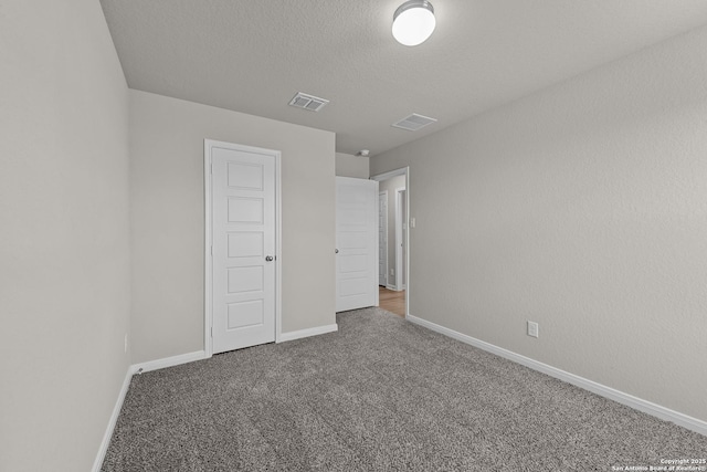 unfurnished bedroom with carpet, a textured ceiling, and a closet