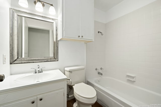 full bathroom with tiled shower / bath combo, vanity, and toilet