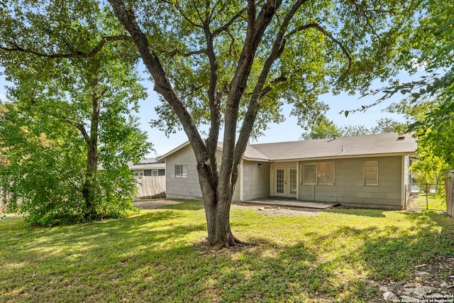 rear view of property featuring a lawn