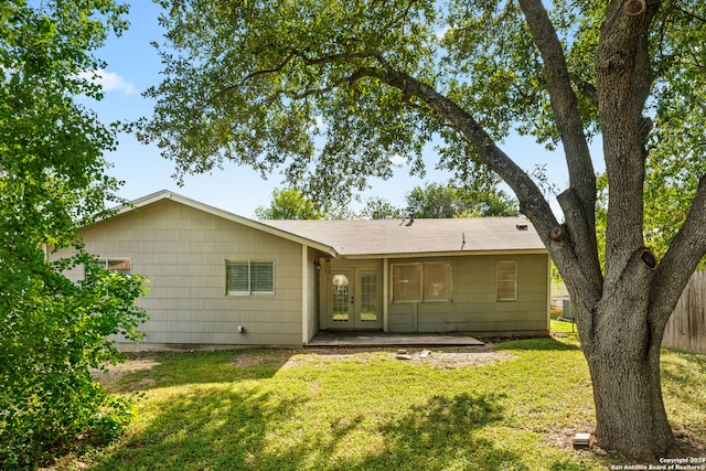 rear view of property featuring french doors and a yard