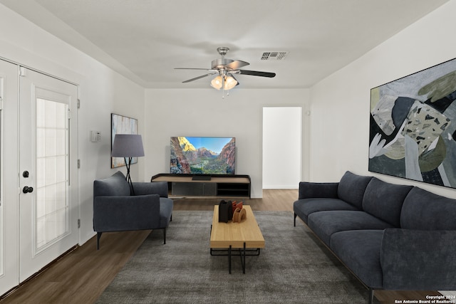 living room with ceiling fan, french doors, and dark hardwood / wood-style flooring