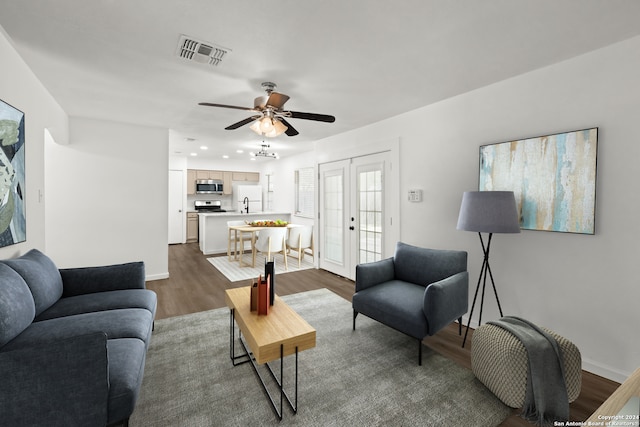 living room featuring ceiling fan, french doors, and dark wood-type flooring