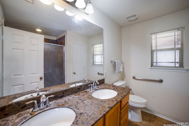 bathroom featuring vanity, tile patterned flooring, toilet, and a shower with door