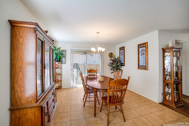 tiled dining room with a chandelier