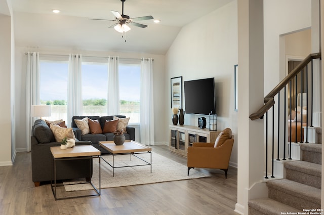 living room with wood-type flooring, ceiling fan, and lofted ceiling