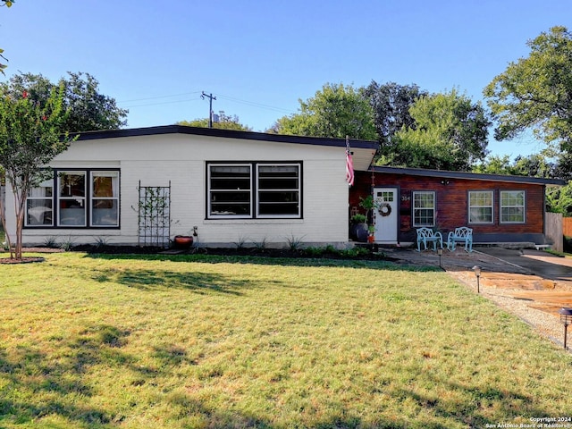 view of front of house featuring a front lawn and a patio