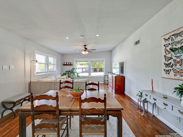 dining room with vaulted ceiling, ceiling fan, hardwood / wood-style floors, and a textured ceiling