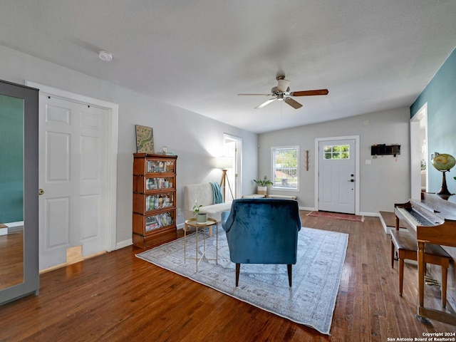 living room featuring dark wood-type flooring and ceiling fan