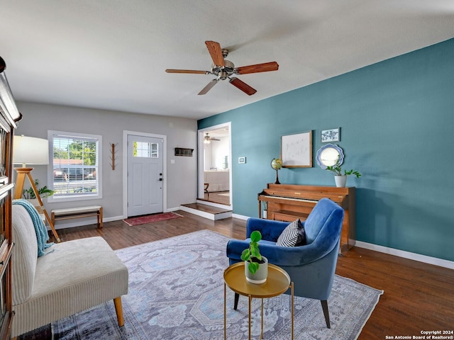 living room featuring ceiling fan and dark wood-type flooring