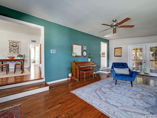 living area with ceiling fan, french doors, and dark hardwood / wood-style flooring