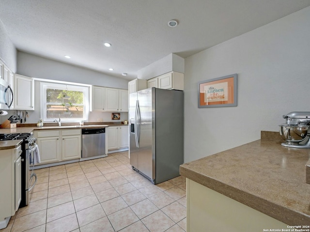 kitchen featuring stainless steel appliances, white cabinets, and light tile patterned floors