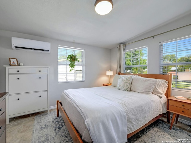 bedroom featuring light tile patterned flooring, a wall unit AC, and multiple windows