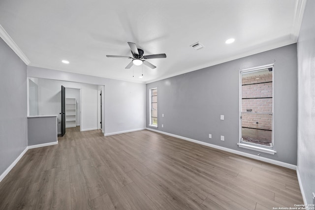 empty room with crown molding, ceiling fan, and light hardwood / wood-style flooring