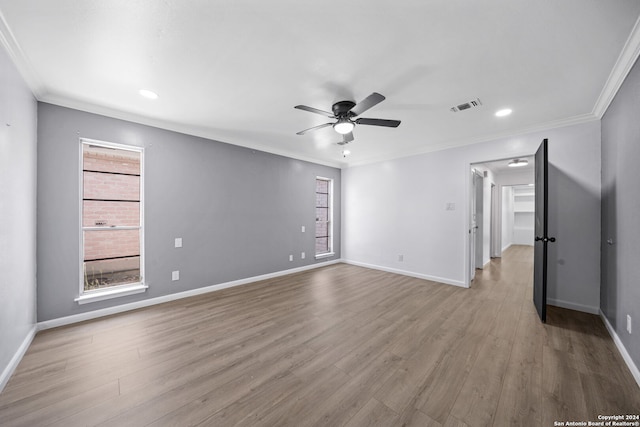 empty room featuring ornamental molding, light hardwood / wood-style flooring, and a wealth of natural light