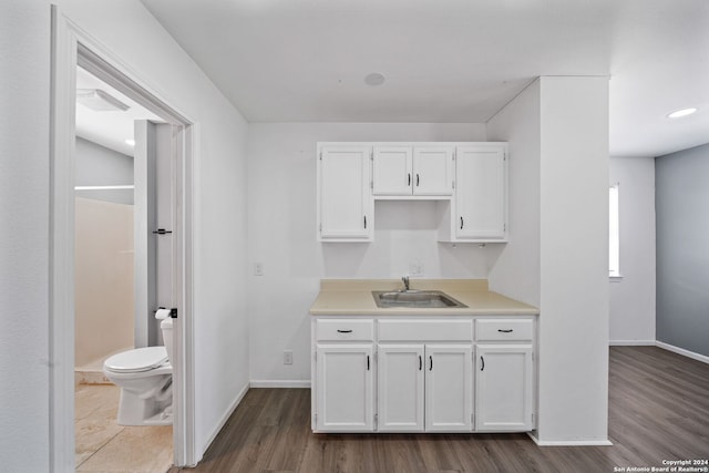 kitchen with sink, hardwood / wood-style floors, and white cabinets