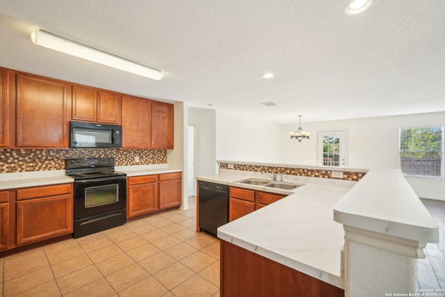 kitchen featuring black appliances, tasteful backsplash, decorative light fixtures, light tile patterned floors, and sink