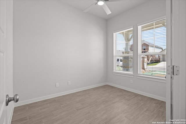 empty room featuring light hardwood / wood-style floors, a wealth of natural light, and ceiling fan