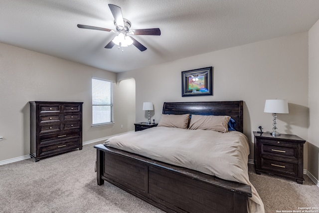 carpeted bedroom featuring ceiling fan and a textured ceiling