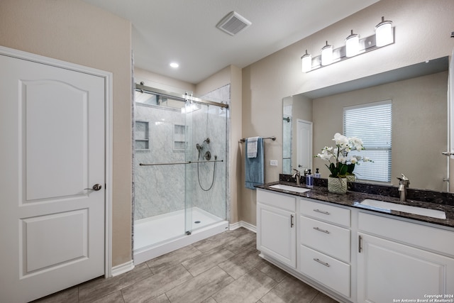 bathroom featuring walk in shower and vanity