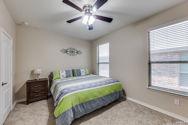 carpeted bedroom featuring ceiling fan and multiple windows