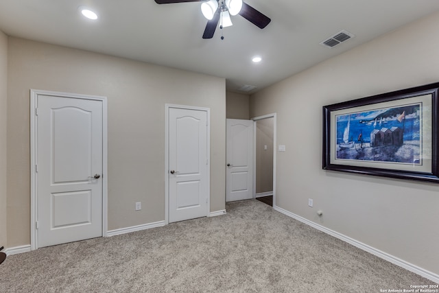 unfurnished bedroom with ceiling fan and light colored carpet