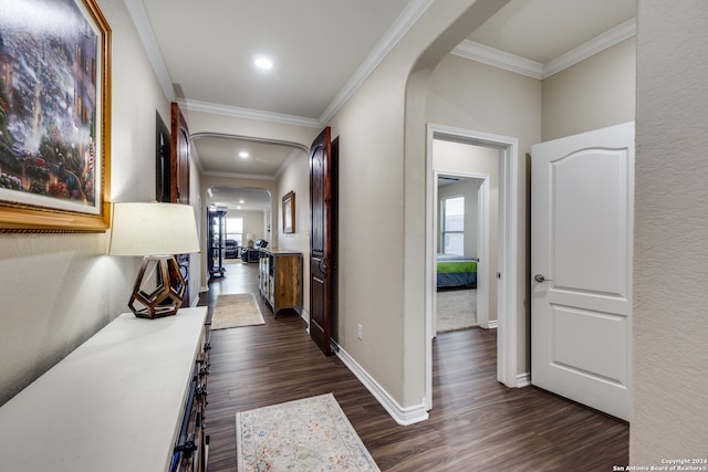 hall with dark wood-type flooring and ornamental molding