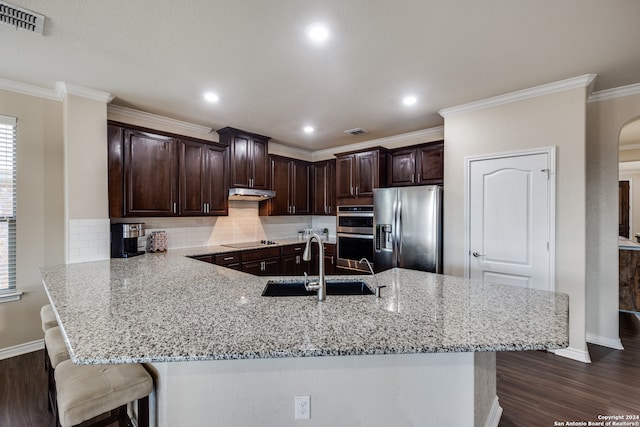 kitchen with a breakfast bar area, dark wood-type flooring, sink, stainless steel appliances, and ornamental molding