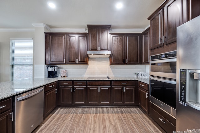 kitchen featuring light stone countertops, ornamental molding, appliances with stainless steel finishes, dark brown cabinets, and backsplash