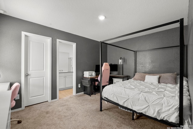 bedroom with light carpet, connected bathroom, and a textured ceiling