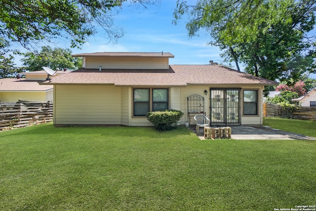 rear view of property with a patio and a lawn