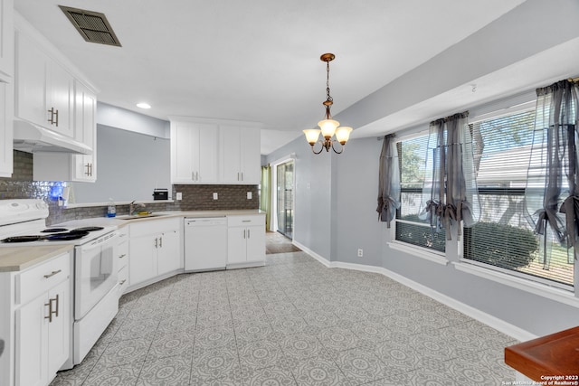 kitchen featuring white appliances, hanging light fixtures, white cabinets, and sink