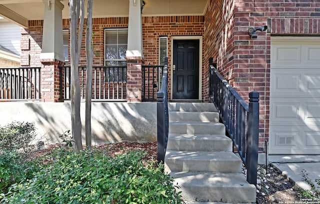 doorway to property with a porch and a garage