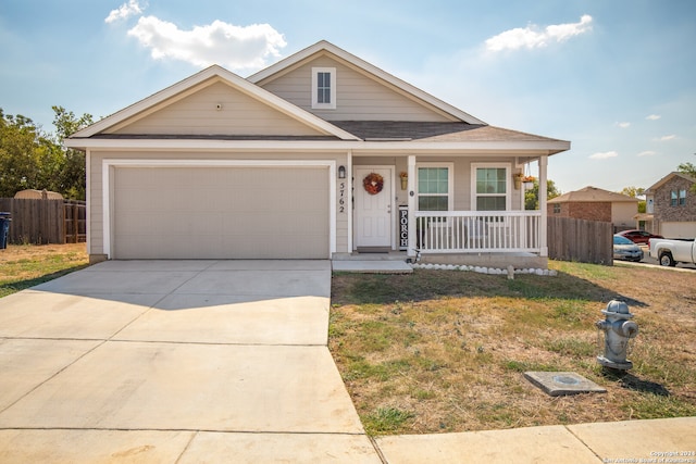 view of front facade with a garage, a porch, and a front lawn