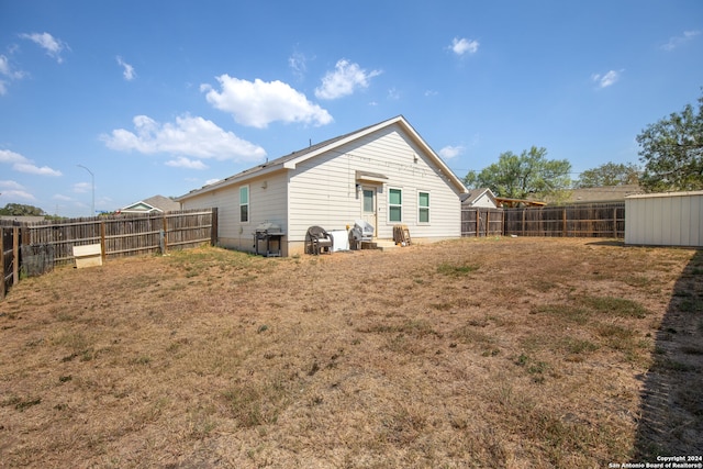 back of property featuring a storage unit