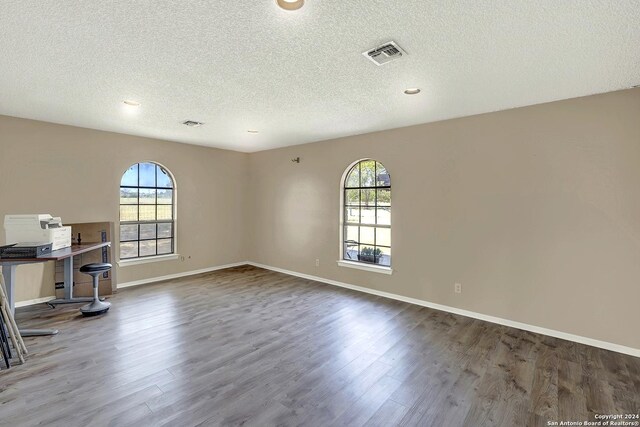 6776 Green Valley Rd, Cibolo, TX 78108 - unfurnished living room with arched walkways, plenty of natural light, wood finished floors, and ceiling fan