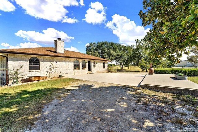 6776 Green Valley Rd, Cibolo, TX 78108 - unfurnished living room featuring beam ceiling, arched walkways, a chandelier, wood finished floors, and a stone fireplace