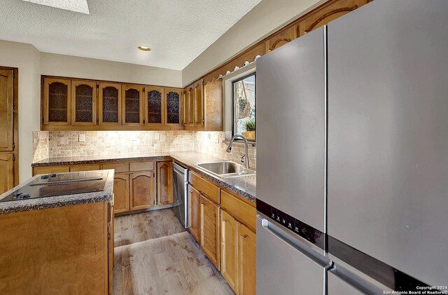 6776 Green Valley Rd, Cibolo, TX 78108 - kitchen with arched walkways, visible vents, wood finished floors, brown cabinetry, and appliances with stainless steel finishes