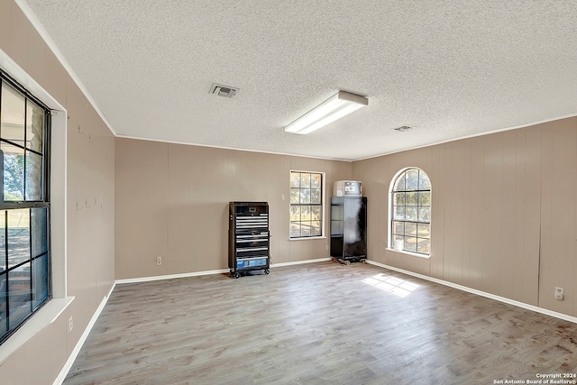 spare room with hardwood / wood-style flooring and a textured ceiling