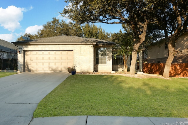 single story home featuring a front lawn and a garage