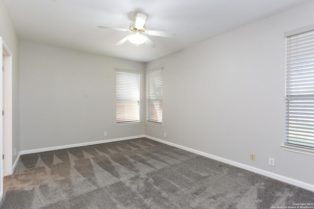 carpeted spare room with ceiling fan