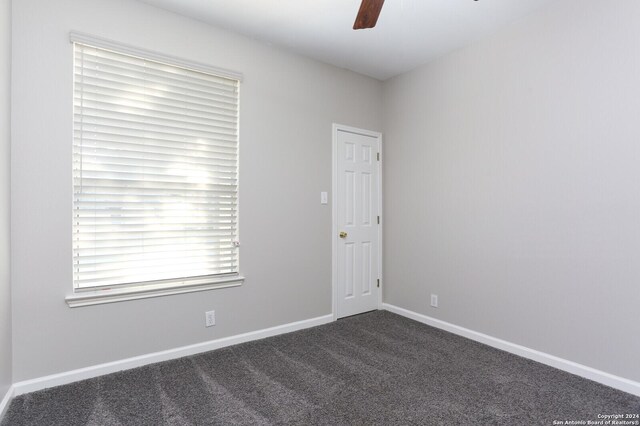 carpeted spare room with ceiling fan