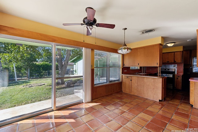 kitchen with ceiling fan, light tile patterned floors, kitchen peninsula, decorative light fixtures, and stainless steel oven