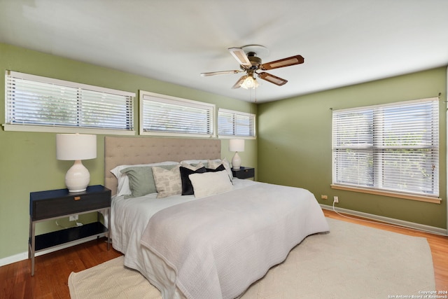 bedroom featuring hardwood / wood-style floors, multiple windows, and ceiling fan