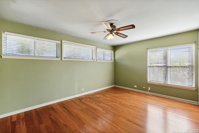 spare room with ceiling fan, light wood-type flooring, and a healthy amount of sunlight