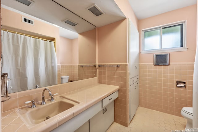 bathroom with tile walls, tile patterned floors, vanity, and toilet