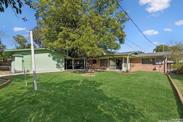 rear view of property featuring a lawn