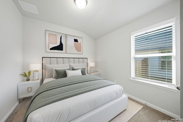 bedroom with light colored carpet and lofted ceiling