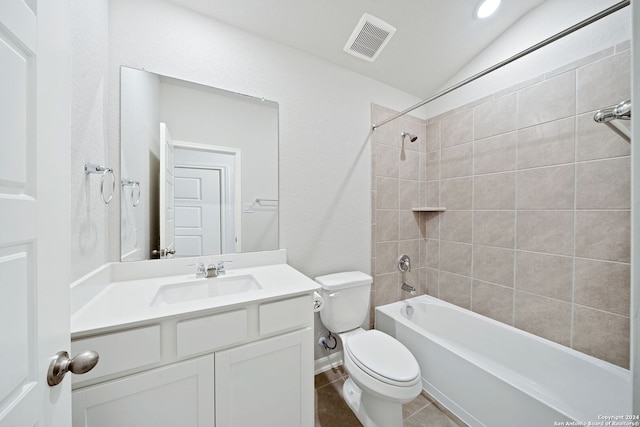 full bathroom with lofted ceiling, vanity, tiled shower / bath combo, tile patterned floors, and toilet